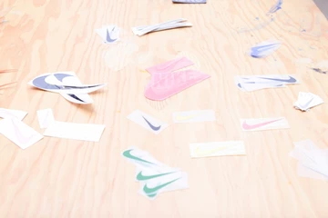 viele bunte Nike Swoosh liegen auf einem braunen Tisch