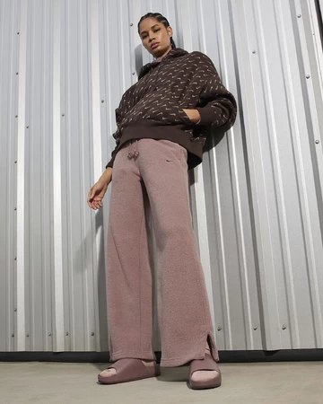 Ein Model trägt die Nike Calm Slide Smokey Mauve