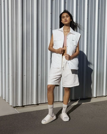 Ein Model trägt den Nike Calm Slide Phantom am Fuß