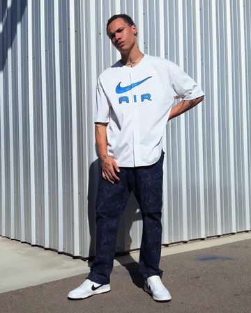 Ein Model trägt den Dunk Low Next Nature Photon Dust Obsidian