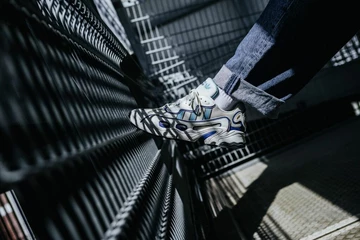 adidas Ozweego OG Royal Blue Schuh wird von der Sonne durch Gitter angestrahlt