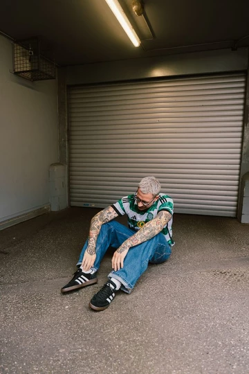 adidas Handball Spezial Core Black Christopher sitzt vor einer Garage