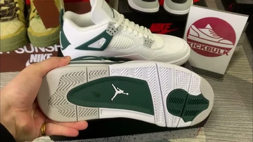 Jemand hat den Jordan 4 Oxidized Green in der Hand und zeigt die Sohle