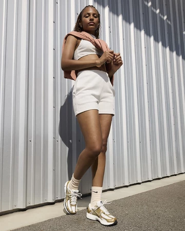 Ein Model trägt den Nike Zoom Vomero 5 Gold am Fuß