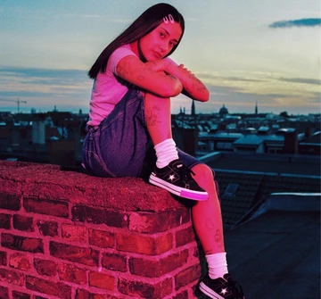 Converse One Star Pro City Edition Berlin Pink Girl auf einer Mauer