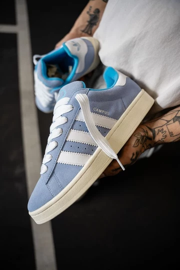 Campus 00s Baby Blue in der Hand vom Model die drei Streifen