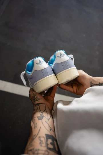 Campus 00s Baby Blue in der Hand vom Model von hinten