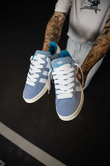 Campus 00s Baby Blue in der Hand vom Model von vorne