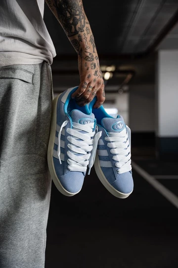 Campus 00s Baby Blue in der Hand vom Model schräg