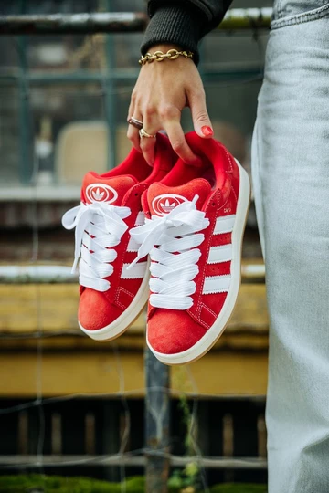Clara hält den adidas Campus 00s Scarlet Red in der Hand