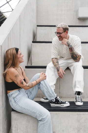 Clara und Christopher sitzen auf einer Treppe und tragen den Converse Chuck 70's