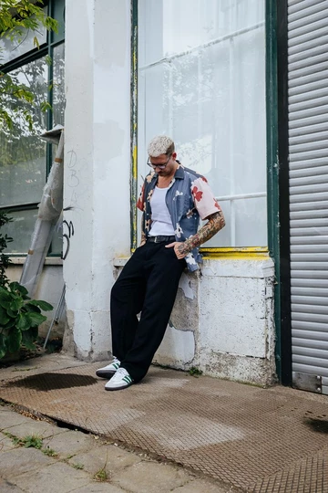 Lookbook Bilder vom adidas Samba Collegiate. Christopher lehnt an einer Wand