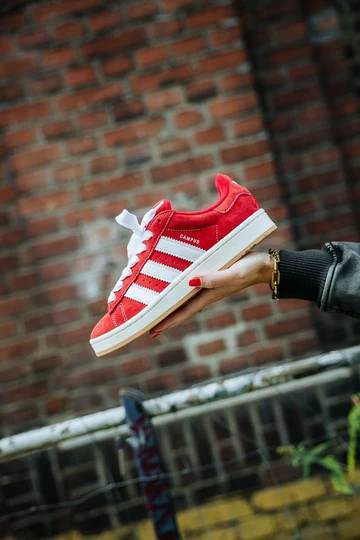 Clara hält den adidas Campus 00s Scarlet Red in der Hand