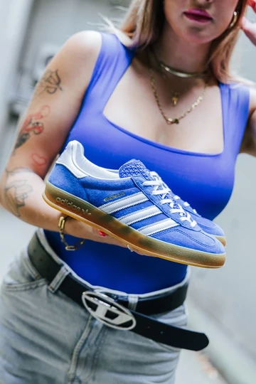Clara hält die
adidas Gazelle Indoor Blue in der Hand