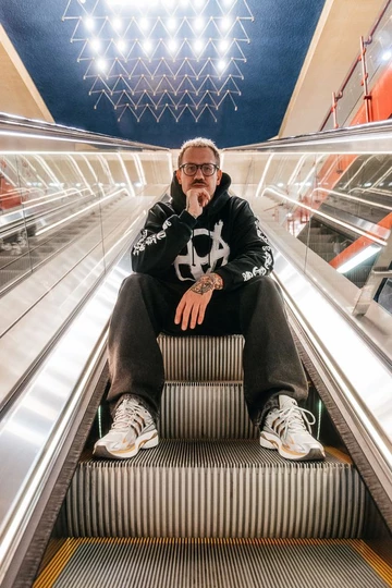 adidas Adistar Cushion 3 Gold Metallic - Christopher trägt den Schuh und sitzt auf einer Rolltreppe