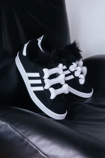 Jeremy Scott adidas Campus drapiert auf einem Sessel, damit man die Details erkennen kann