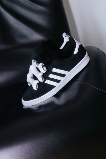 Jeremy Scott adidas Campus drapiert auf einem Sessel, damit man die Details erkennen kann