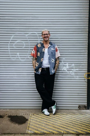 Lookbook Bilder vom adidas Samba Collegiate. Christopher lehnt an einem Tor