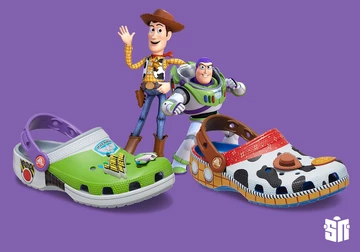 Der Crocs Classic Clog Woody und der Buzz Lightyear Croc auf lila Hintergrund mit beiden Pixar Figuren