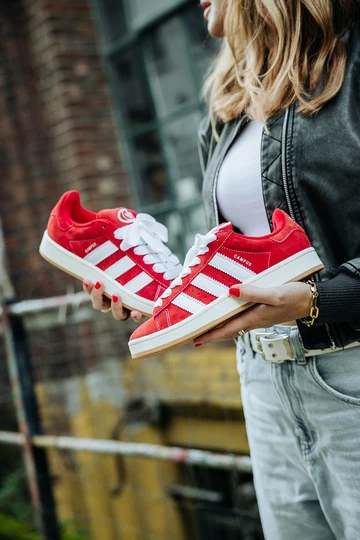 Clara hält den adidas Campus 00s Scarlet Red in der Hand