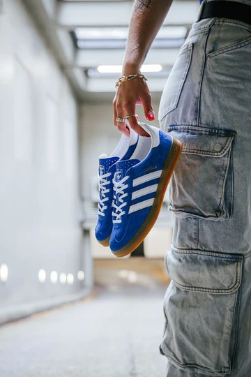 Clara hält die
adidas Gazelle Indoor Blue in der Hand