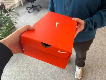 Eine Person überreicht der anderen bei einem Hookup einen Sneaker Karton