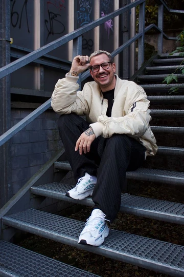 adidas OZMILLEN - Lookbook Shooting mit Christopher. Er sitzt auf einer Treppe