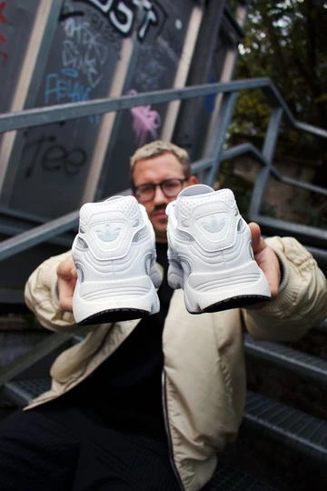 adidas OZMILLEN - Lookbook Shooting mit Christopher. Er streckt den schuh in die Kamera