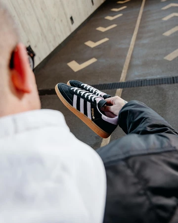 Christopher hält einen adidas Spezial in der Hand, sie sind deshalb "Un DS"