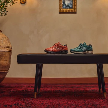 New Balance 990v4 Mahagony und Teal auf einer Bank