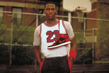 Michael Jordan posiert mit dem jordan 1 high bred auf einem Basketballplatz