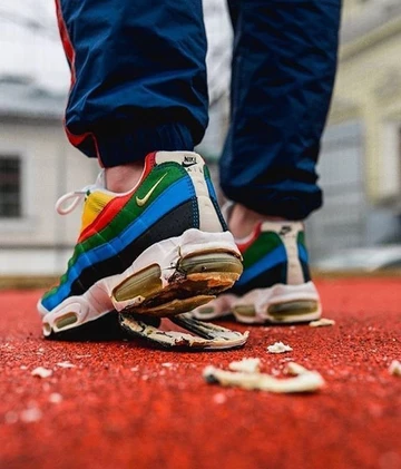 Jemand trägt sehr abgelaufene Air Max 95 am Fuß