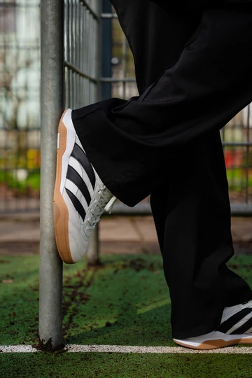 Christopher trägt den adidas Predator Mundial am Fuß, er lehnt an einem Fußballtor