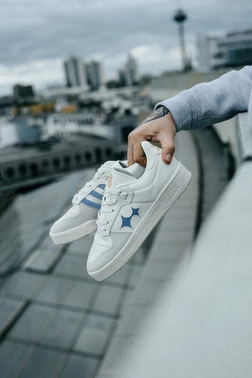 Christopher hält den BSTN x Real Madrid x adidas Rivalry Low 86 in der Hand