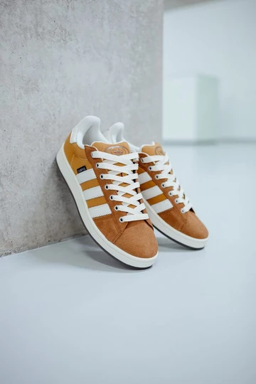 Der adidas Campus 00s Mesa Brown lehnt an der Wand