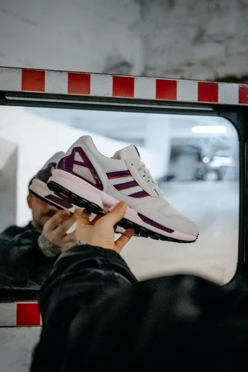 Christopher hält den adidas ZX8000 Glory Purple vor einen Verkehrsspiegel