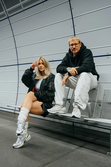 Christopher und Clara sitzen auf einer Bank, Clara trägt den neuen Nike V2K Run OG