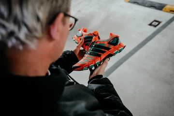 Christopher hält den adidas adistar Raven in der Hand und schaut ihn an