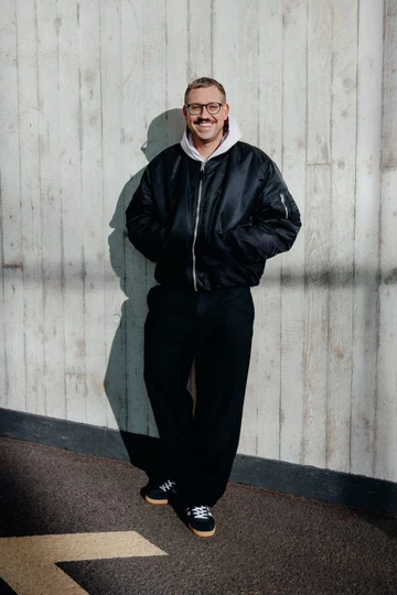 Christopher trägt den adidas Handball Spezial Black Clear Pink und steht an einer Betonwand