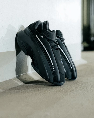 Der adidas Mad IIInfinity Black lehnt an der Wand