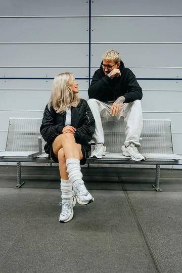 Christopher und Clara sitzen auf einer Bank, Clara trägt den neuen Nike V2K Run OG