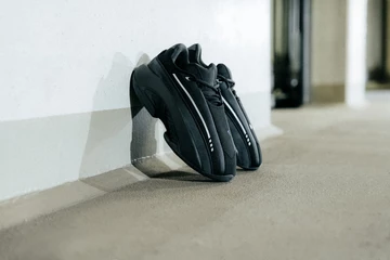 Der adidas Mad IIInfinity Black lehnt an der Wand