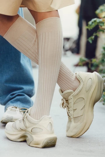 DerAURALEE New Balance WRPD Runner in Bone am Fuß eines Models