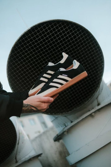 Christopher hält den adidas Samba Black Wonder White im Wales Bonner Style in der Hand