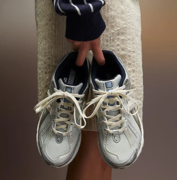 Jemand hält den Kith New Balance 1906R White Blue in der Hand