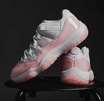 Jordan 11 Low Legend Pink Paar vor schwarzem Hintergrund