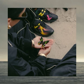 Bricks & Wood x New Balance 1906U Black Multi mit Schmetterling in der Hand