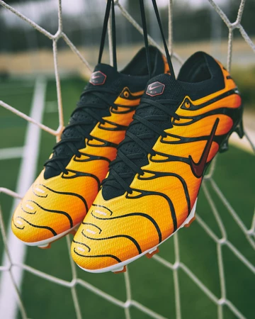 Der Air Max Plus Mercurial Vapor 15 Pimento hängt auf einem Fußballplatz im Tor